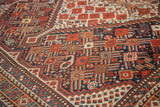Antique Shiraz rug's hand-knotted tribal pattern with rich red, navy, and ivory tones.