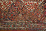 Close view of an Antique Shiraz carpet's tribal geometric patterns, distinct borders, and visible foundation.