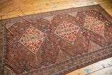 Antique Shiraz carpet detail with tribal patterns, stepped contour, and visible foundation wear.