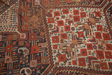Antique Shiraz rug's tribal geometric patterns; red fruit motifs on ivory, navy, and zigzag border.