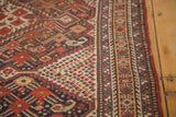 Antique Shiraz tribal rug close-up: geometric patterns, multi-band border, and worn pile.
