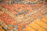 Antique Karaja rug corner with tattered end and geometric patterns in brick red, sky blue.
