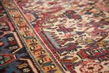 Ivory field with serrated leaf motif and traditional turtle border of a vintage Heriz rug.