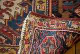 Vintage Heriz carpet edge: ivory field, fringe, sturdy binding, and hand-knotted foundation.