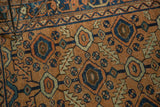 Detail of antique Persian Lilihan rug's apricot, sky blue, ivory concentric circle and serrated leaf pattern.