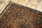 Antique Lilihan rug detail: apricot field, sky blue geometric patterns, tattered edge.