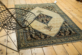 Antique Malayer Serab rug corner with navy border and ornate ivory field shrubs.