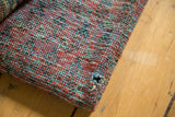 Hand-knotted back of an antique Malayer rug showing mottled weave, exposed foundation, and hole.