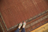 Antique Malayer runner with repeating cinnabar red boteh field and contrasting geometric border details.