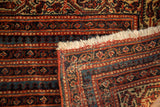 Folded Malayer antique rug, showcasing rich brick red, sky blue multi-mini borders, and fringe.