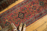 Hand-knotted vintage Lilihan runner with a raspberry red field and blue floral medallion.