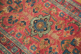 Hand knotted Lilihan rug with raspberry red field and mallard green floral medallion.