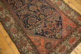 Antique Malayer rug corner showcasing intricate floral vinery and arabesques in navy, coral, and beige.