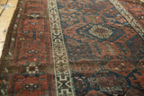 Antique Belouch runner's geometric ivory border and aged field in navy and dark copper.