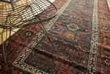 Geometric triple medallion and trellis design on this antique Belouch runner, with deep navy and copper tones.