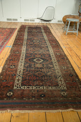 Antique Belouch runner's geometric border, dark striped kilim bands, and ivory fringe.