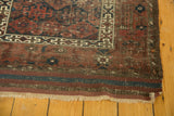 Antique Belouch runner's corner with striped kilim, fringe, and storied geometric patterns.