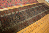 Antique Belouch runner: geometric trellis motif in copper, navy, and ivory with aged texture.