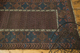 Antique Belouch rug's main border with oversized indigo guls, terra cotta wave, and edge wear.