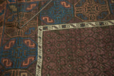 Worn aubergine boteh field and indigo geometric border on an antique Belouch rug.