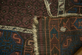 Tattered original goat hair selvage, hand-knotted foundation, and aubergine pile on an antique Belouch rug.