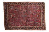 Hand-knotted vintage American Sarouk rug: burgundy red field, center medallion, floral pinwheel designs.
