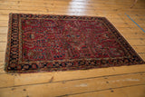 Side edge of vintage Sarouk rug with tatter and navy floral border.
