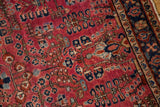 American Sarouk rug, burgundy red field with navy blue floral and pinwheel motifs.