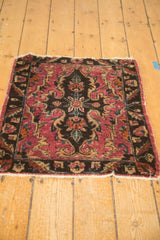 Bottom edge of antique Lilihan rug mat, showing tatter, open ends, and raspberry serrated motifs.