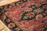 Corner detail of antique Lilihan rug, revealing fuchsia, dark chocolate, and beige rococo motifs.