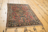 Intricate floral vinery on the antique Lilihan rug's low pile in raspberry and navy.