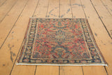 Lower corner of antique Persian Lilihan rug, low pile, raspberry field, navy border, fabric-capped end.