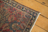 Antique Lilihan rug corner showing navy border, delicate floral vinery, and secured end.