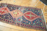 Triple geometric medallions and rich pictorial motifs on a navy blue vintage Soumac runner.