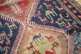 Hand-woven Soumac detail with geometric camel and bird motifs in navy, red, beige.