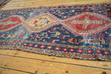 Hand-woven Soumac rug with navy blue field, stylized animals, and red border.