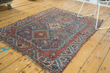 Antique Qashqai rug with a field of tribal motifs and interconnected diamond medallions.