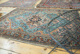 Traditional Lilihan rug's intricate floral border, aqua blue field, and tattered fringe.