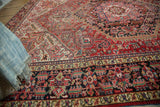 Ornate traditional navy blue Heriz carpet border with brick red, pale gold, and mallard green motifs.