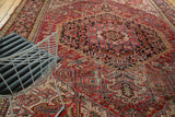 Vintage Heriz rug displaying ornate serrated leaves, scrolling designs, and pearl motifs.