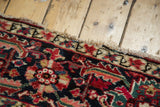 Vintage Heriz carpet edge, detailed red, navy, ivory serrated leaves and pile wear.