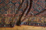Antique Kurdish runner: geometric border, navy Garden of Paradise motif, madder red, saffron, and end tatter.