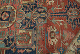 Madder red, navy, and powder blue geometric tendrils with stylized floral elements on an antique Serapi carpet.