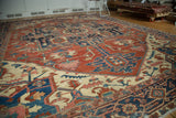 Antique Serapi carpet, geometric floral field in brick red, navy, ivory, and selvage patina.