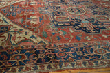 Antique Serapi rug with madder red geometric tendrils, ornate florals, and a patinaed navy border.