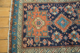 Antique Karaja rug corner with geometric floral patterns, low pile, navy, red, and blue.