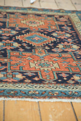 Textural view of antique Karaja rug's low pile with madder root red and navy geometric motifs.