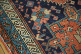 Antique Karaja rug, serrated madder red field and navy geometric florals, beige border.