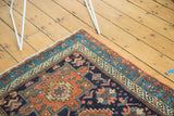 Antique Karaja rug corner with intricate geometric floral field, featuring madder red, sky blue, ivory borders.