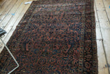 Early 20th century American Sarouk rug detail: curvilinear floral motifs, low pile, dusty rose and navy.